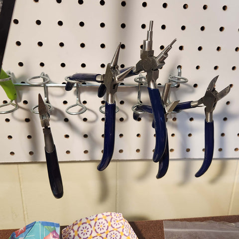 Pliers and cutters used for jewelry repair, hanging on pegboard. Located in Mar Silver Jewelry