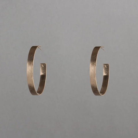 Gold hoop earrings on a gray background