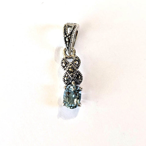 small marcasite and silver pendant with oval blue topaz prong set
